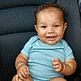 baby, child, smiling, curly_hair, onesie, car_seat, chubby, happy, infant, cute, portrait, skin, feet, hands, sitting, indoors, seatbelt, clothing, person, vehicle_interior