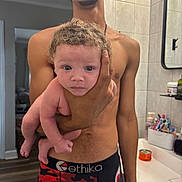 Remiri is registered to the contest to win money with this photo: baby, child, person, man, shirtless, bathroom, mirror, sink, toiletries, toothbrush, hand, curly_hair, flooring, tile_wall, mirror_reflection, container, grooming, expression, holding, indoor