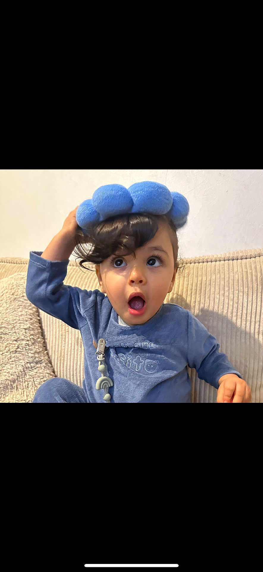 Kaysan participe au concours pour gagner de l'argent avec cette photo : toddler, child, blue_outfit, headband, surprised_expression, curly_hair, couch, indoor, cozy, plush, person, cute, young_child, seated, home, face, wide_eyes, open_mouth, casual_clothing, curiosity