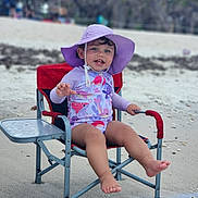 Valeria joined the competition — help win amazing prizes! toddler, child, beach, sunhat, swimsuit, chair, water, sand, smile, happy, outdoor, summer, vacation, playful, sitting, feet, reflection, nature, relaxation, holiday