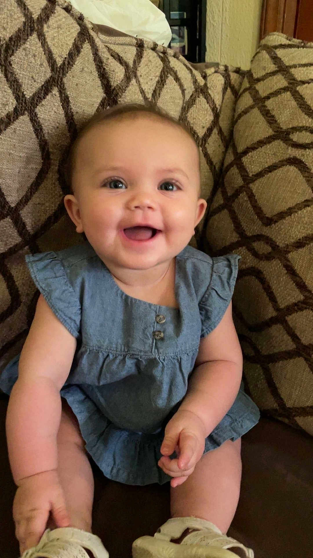 Anisliegh joined the competition — help win amazing prizes! baby, child, smiling, blue_dress, sitting, couch, patterned_cushion, happy, indoor, cute, infant, footwear, small_hands, eyes, face, skin, cheeks, short_hair, buttons, soft_lighting
