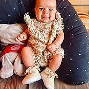 Livia participe au concours pour gagner de l'argent avec cette photo : baby, smiling, infant, romper, shoes, cushion, star_pattern, indoor, cute, happy, child, person, seat, plush, cozy, clothing, footwear, portrait, skin, expression