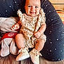 baby, smiling, infant, romper, shoes, cushion, star_pattern, indoor, cute, happy, child, person, seat, plush, cozy, clothing, footwear, portrait, skin, expression