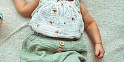 Livia participe au concours pour gagner de l'argent avec cette photo : baby, blanket, button, child, clothing, cute, expression, face, foot, green_pants, hand, happy, indoors, infant, lying_down, portrait, skin, smiling, soft_texture, white_top