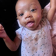 Ja'Lasia joined the competition — help win amazing prizes! baby, child, face, smile, happy, arm, clothing, onesie, patterned_clothing, messy, food_stains, skin, head, eyes, mouth, fingers, earrings, blanket, indoor, portrait