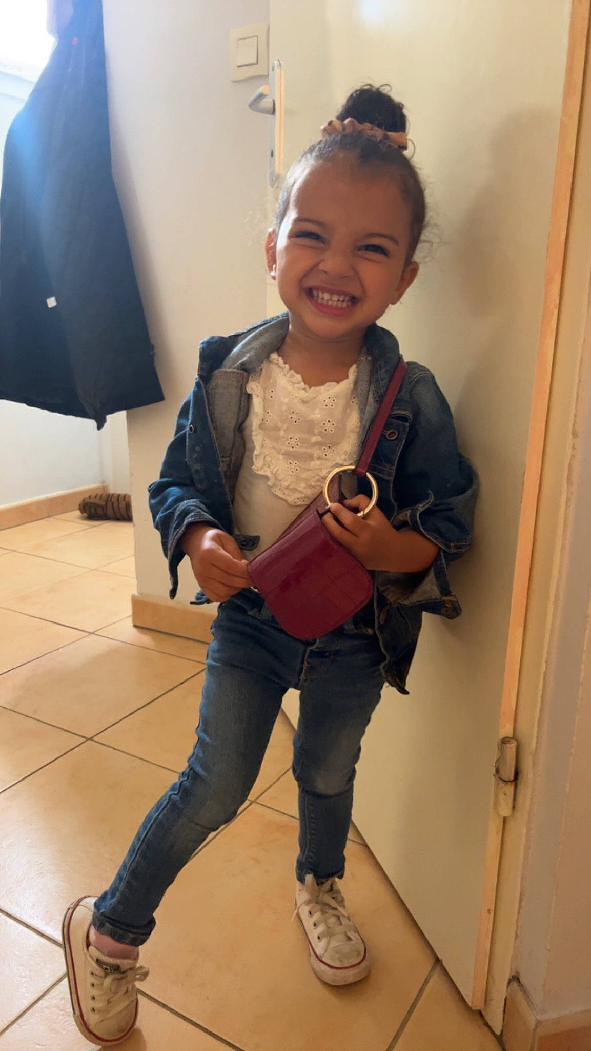 Aleyna participe au concours pour gagner de l'argent avec cette photo : bag, eyewear, flooring, footwear, hairstyle, happy, jeans, joy, knee, lamp, luggage_and_bags, person, shoe, shoulder, sleeve, smile, sneakers, standing, thigh, toddler
