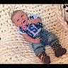 baby, infant, blanket, clothing, denim, footwear, pattern, stars, stripes, patriotic, cute, smiling, lying_down, soft_texture, portrait, child, happy, indoor, casual, newborn