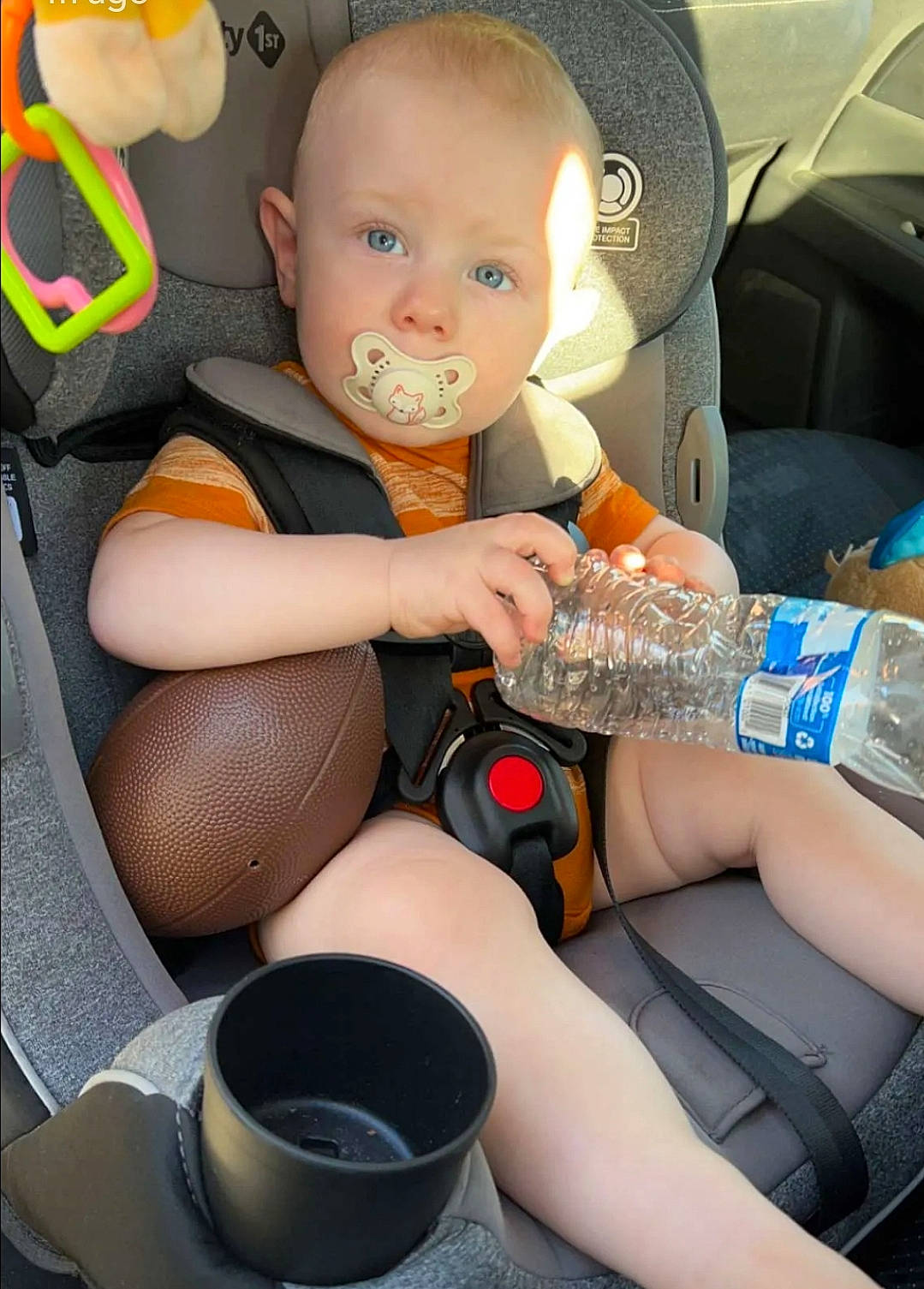 Rush is registered to the contest to win money with this photo: auto_part, baby, baby_toddler_clothing, bottled_water, car_seat, car_seat_cover, child, comfort, drinking_water, drinkware, human_leg, lap, leg, nail, person, plastic_bottle, sitting, steering_wheel, thigh, toddler
