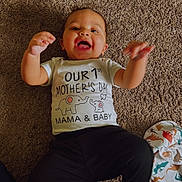 Kaiden joined the competition — help win amazing prizes! baby, child, smiling, carpet, clothing, tshirt, happy, indoor, infant, lying_down, person, blanket, animal_print, floor, cute, celebration, mother's_day, raised_hands, cheerful, casual