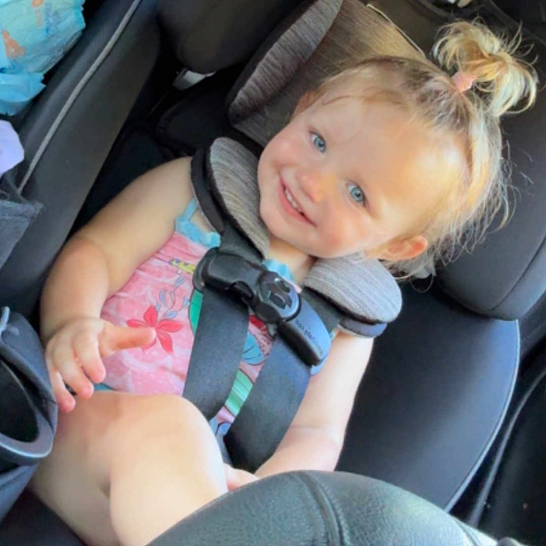 Everleigh joined the competition — help win amazing prizes! child, toddler, baby, smiling, car, car_seat, seatbelt, harness, portrait, blonde_hair, blue_eyes, indoor, vehicle, passenger, sitting, pink_dress, safety, travel, happy, photography