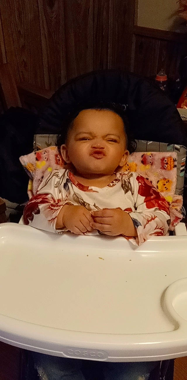 Karissa is registered to the contest to win money with this photo: baby, baby_toddler_clothing, chair, cheek, child, chin, comfort, event, finger, forehead, fun, happy, linens, lip, mouth, person, pink, room, sitting, skin