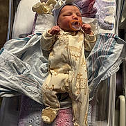Kinleigh is registered to the contest to win money with this photo: newborn, baby, pacifier, onesie, booties, hat, blanket, hospital_bassinet, sleeping, infant, clothing, bottle, soft_toys, knit_blanket, baby_care, cozy, cute, resting, indoors, person