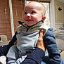 Declan is registered to the contest to win money with this photo: baby, child, smiling, indoor, person, hands, clothing, jacket, sleeves, couch, window, blinds, furniture, happy, toddler, portrait, holding, cozy, home, infant