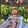 Kennidi is registered to the contest to win money with this photo: baby, walker, toy, duck_toy, outdoor, canopy, decoration, ladybug, butterfly, greenery, adult, table, sunlight, child, summer, nature, playtime, happy, park, family