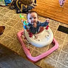 baby, walker, toy, dog, blanket, floor, tile_floor, wood_floor, pet_bowl, household, indoor, curious, child, animal, play, furniture, smile, person, pet_accessory, cozy