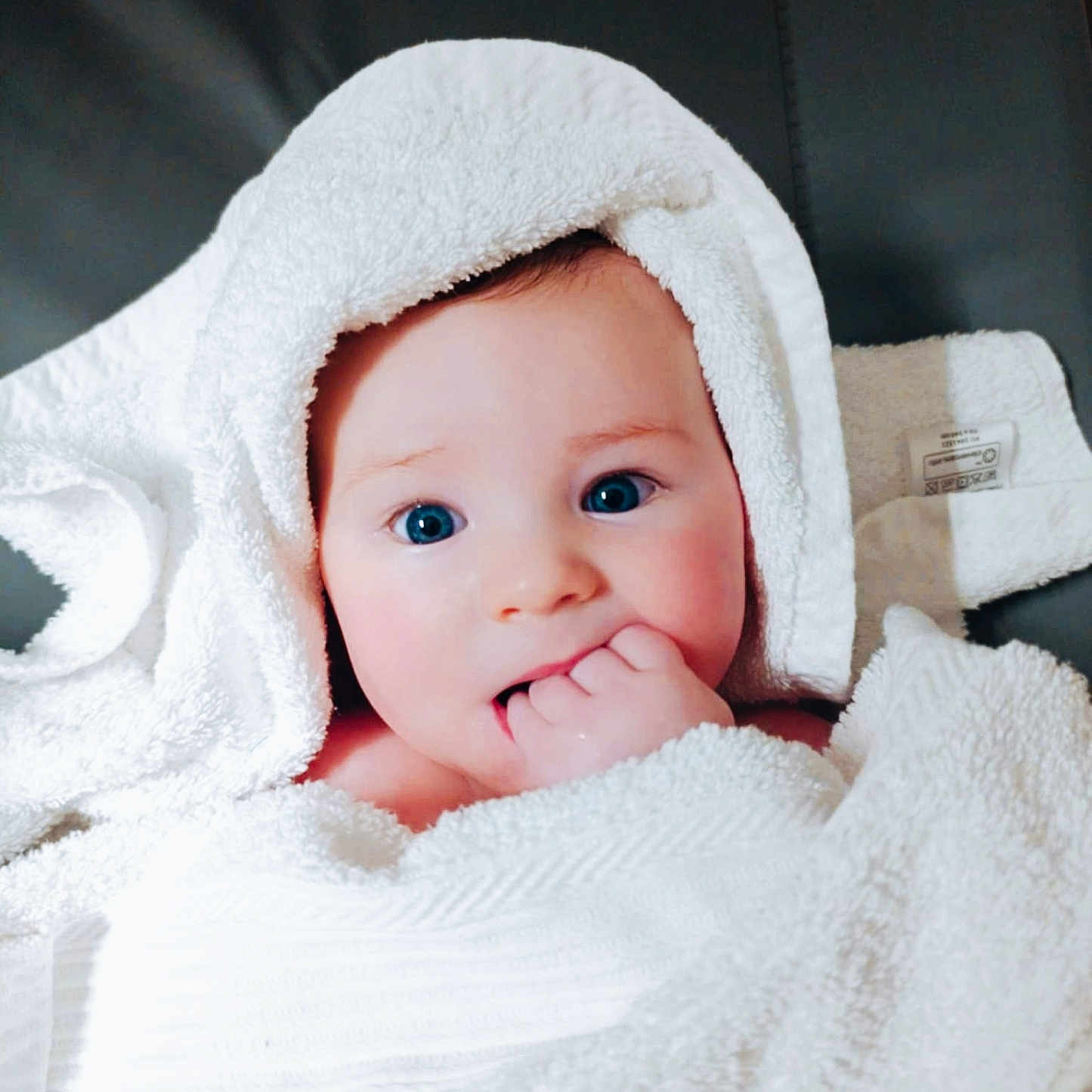 Léo participe au concours pour gagner de l'argent avec cette photo : baby, bath, blue_eyes, child, closeup, comfort, cute, expression, face, hand, indoors, infant, newborn, person, portrait, skin, soft, towel, white, wrapped