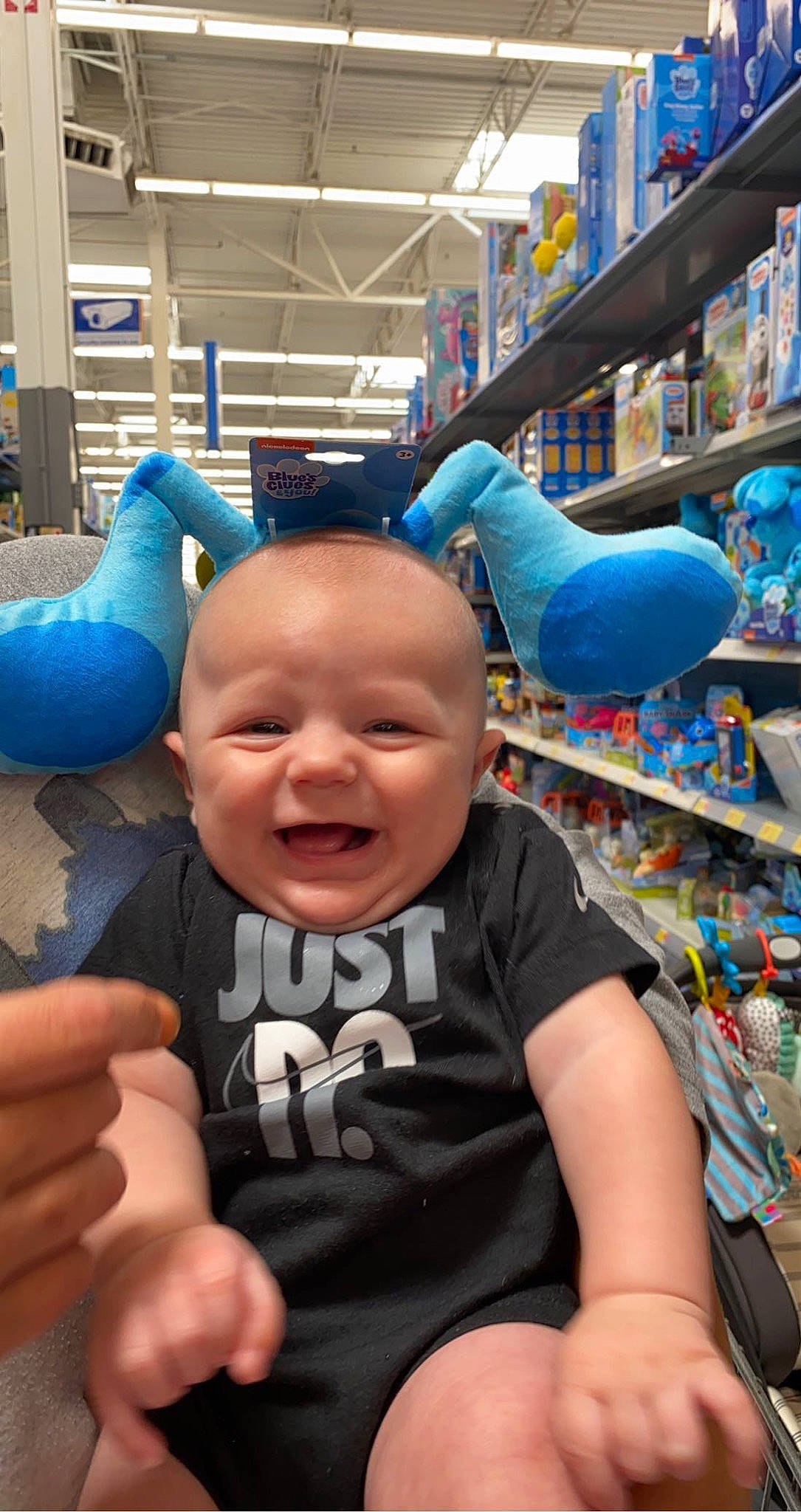 Creed is registered to the contest to win money with this photo: baby, baby_toddler_clothing, blue, child, fun, happy, leisure, people, person, play, retail, shelf, shorts, sitting, smile, t_shirt, thumb, toddler, toy, vacation