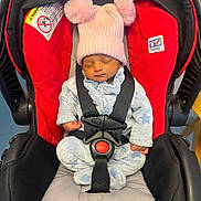 Vyom joined the competition — help win amazing prizes! baby, sleeping, car_seat, pink_hat, pom_poms, blue_onesie, star_pattern, infant, child, safety_harness, red_car_seat, black_straps, cozy_clothing, indoors, peaceful, cute, newborn, headwear, toddler, seatbelt