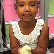 Nevaeh joined the competition — help win amazing prizes! animal, chick, child, colorful, curly_hair, cute, floral_skirt, gentle, girl, happy, holding, indoor, person, pet, portrait, smile, storage_bins, white_top, yellow_chick, young_child