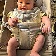Alessio a rejoint le concours — aidez-le/la à gagner de superbes lots ! baby, infant, bouncer, babybjorn, bib, yellow_clothing, smile, happy, cute, indoors, carpet, wooden_floor, baby_seat, child, person, legs, arms, face, skin, comfort