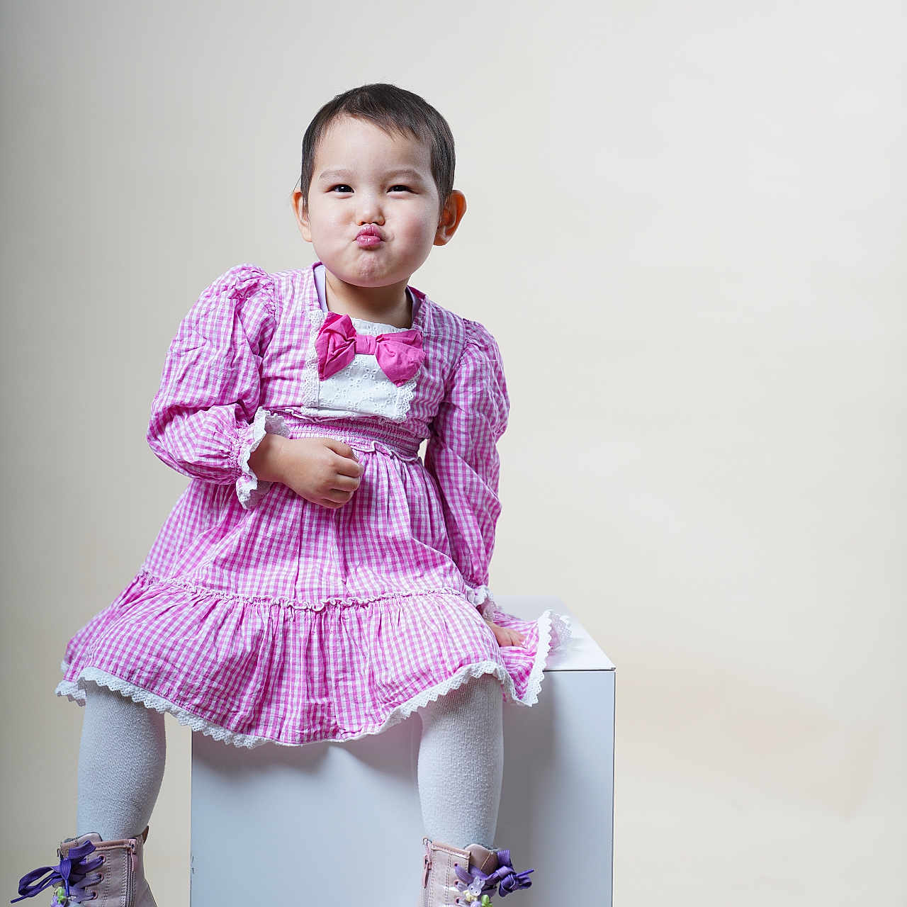 Tenuunjargalan a rejoint le concours — aidez-le/la à gagner de superbes lots ! boots, bow, child, cute, expression, fashion, funny_face, indoor, light_background, pink_dress, portrait, pouting, purple_laces, short_hair, sitting, studio, toddler, white_cube, white_tights, young_child