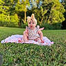 baby, child, infant, outdoor, garden, grass, blanket, bow, headband, floral_outfit, sitting, portrait, smiling, face, blue_eyes, sunlight, nature, park, colorful, photography