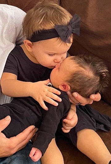 Ella is registered to the contest to win money with this photo: abdomen, baby, cheek, child, comfort, elbow, finger, fun, gesture, happy, human_leg, interaction, joint, knee, muscle, person, shoulder, thigh, thumb, toddler