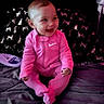 Zariya is registered to the contest to win money with this photo: baby, infant, child, smiling, happy, sitting, portrait, pink_outfit, onesie, bed, blanket, bedroom, indoor, face, hands, feet, bald, joyful, patterned_fabric, photograph