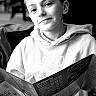 Antoine participe au concours pour gagner de l'argent avec cette photo : boy, child, portrait, black_and_white, menu, indoor, smile, hoodie, seated, face, young, casual_clothing, expression, blurred_background, monochrome, person, reading, happy, candid, text_overlay
