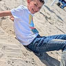 Antoine a rejoint le concours — aidez-le/la à gagner de superbes lots ! child, boy, smiling, beach, sand, casual_clothing, tshirt, jeans, barefoot, sunny, outdoor, portrait, relaxed, happy, summer, daylight, playful, vacation, youth, fun