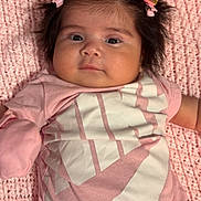 Isabela is registered to the contest to win money with this photo: baby, infant, pink_clothing, hair_clips, knitted_blanket, lying_down, indoor, portrait, cute, young_child, face, baby_girl, soft_texture, casual_wear, child, newborn, small_hands, happy, cozy, resting