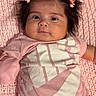 baby, infant, pink_clothing, hair_clips, knitted_blanket, lying_down, indoor, portrait, cute, young_child, face, baby_girl, soft_texture, casual_wear, child, newborn, small_hands, happy, cozy, resting