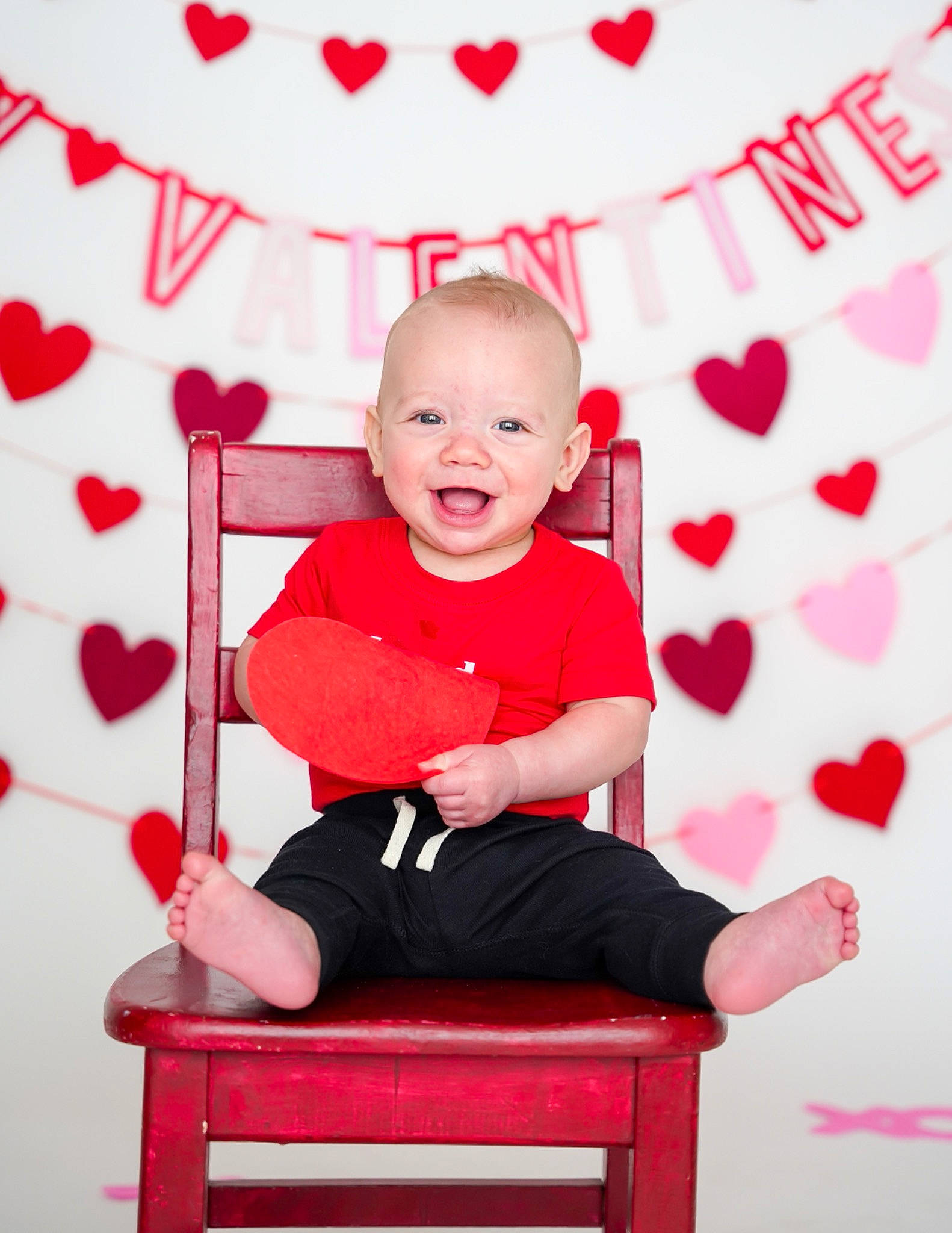 Tyden is registered to the contest to win money with this photo: arm, baby, baby_toddler_clothing, child, comfort, event, fun, happy, leisure, magenta, pattern, person, pink, rectangle, red, sitting, sleeve, smile, standing, toddler