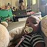 baby, infant, child, pacifier, striped_shirt, plush_toy, stuffed_animal, portrait, indoor, bedroom, sitting, lying_down, wide_eyes, cuddling, toy, crib, home, furniture, television, bottle