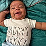 Isaac joined the competition — help win amazing prizes! arm, baby, blanket, blue_pants, casual, child, cozy, cute, fabric, face, hand, happy, indoors, infant, lying_down, onesie, skin, smiling, soft, text_on_clothing