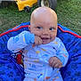baby, infant, smiling, onesie, blue_cushion, outdoor, grass, lawn_mower, hand, playful, happy, seat, palm, head, cheek, eyes, clothing, child, toddler, nature