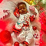 Kaliyah is registered to the contest to win money with this photo: baby, infant, sleeping, christmas, holiday, ornament, candy_cane, lollipop, santa_plush, blanket, onesie, festive, red, decorations, cozy, newborn, toy, peaceful, background_blur, portrait