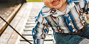 Hendrix is registered to the contest to win money with this photo: toddler, child, smiling, blue_eyes, jeans, shirt, outdoor, sunlight, happy, baby, portrait, sitting, hand, metal_surface, patterned_clothing, cute, casual_wear, closeup, daylight, playful