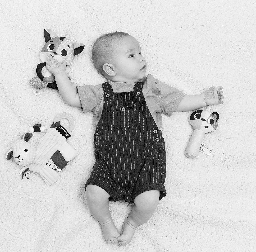 Lewis participe au concours pour gagner de l'argent avec cette photo : arm, baby, baby_toddler_clothing, black_and_white, design, doll, finger, gesture, grey, happy, human_body, monochrome, monochrome_photography, one_piece_garment, pattern, person, sleeve, style, toy, vertebrate