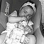 baby, sleeping, car_seat, toy_car, headband, child, infant, sucking_thumb, netting, seatbelt, cute, peaceful, toddler, clothing, indoor, resting, person, accessory, monochrome, portrait