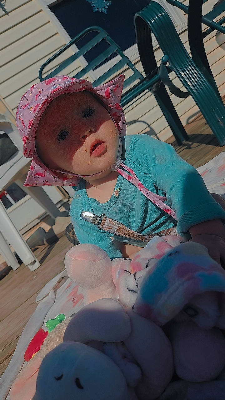 Angela Grace Petersheim joined the competition — help win amazing prizes! baby, baby_products, baby_toddler_clothing, carmine, chair, child, costume, doll, fun, hat, headwear, lap, person, pink, recreation, sitting, toy, winter