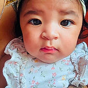 Kataleya joined the competition — help win amazing prizes! baby, infant, child, portrait, close_up, face, eyes, wide_eyed, floral_outfit, dress, party_hat, sparkly, indoor, sitting, adult_arm, tattoo, portrait_photography, looking_at_camera, cute, colorful