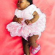 Amina is registered to the contest to win money with this photo: baby, infant, pink_dress, soft_blanket, cute, child, footwear, shoes, curly_hair, chubby_cheeks, laying_down, adorable, portrait, indoor, one_person, young_child, fashion, soft_texture, pretty, resting