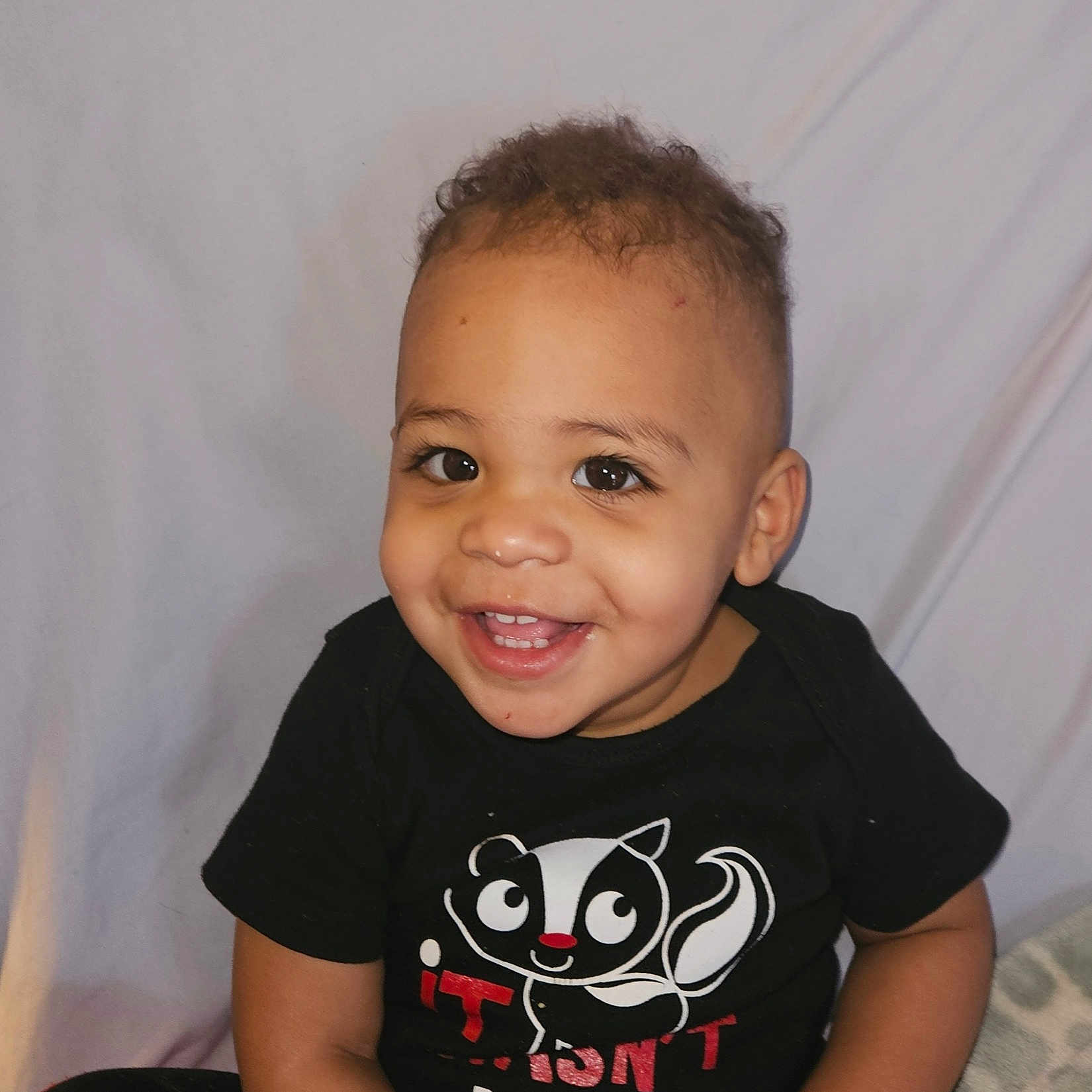 Lucas is registered to the contest to win money with this photo: baby, babylaughing, bodypart, clothing, face, hair, happy, head, indoors, laughing, mouth, pants, person, photography, portrait, shirt, sitting, smile, t_shirt, teeth