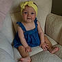 baby, child, blue_eyes, yellow_headband, denim_romper, sitting, cozy_chair, textured_fabric, indoors, cute, smiling, barefoot, small_hands, portrait, infant, comfortable, soft_lighting, happy, young, headwear
