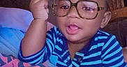 Trustin is registered to the contest to win money with this photo: baby, blanket, casual, child, colorful_shirt, couch, cute, glasses_filter, hand_gesture, happy, indoor, infant, person, playful, portrait, smiling, striped_shirt, tongue_out, wooden_chair, wooden_wall