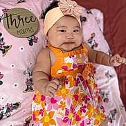 Yennica joined the competition — help win amazing prizes! baby, infant, child, girl, headband, dress, floral_pattern, orange, pink, blanket, minnie_mouse, soft_texture, wooden_sign, three_months, milestone, cute, smiling, lying_down, indoors, portrait