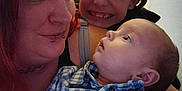 Maverick is registered to the contest to win money with this photo: woman, baby, child, face, smile, indoor, portrait, clothing, checkered_shirt, person, family, happy, holding, closeup, expression, head, hair, skin, choker, lip_piercing
