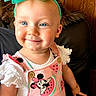 baby, blue_eyes, bow, bracelet, child, cute, earrings, happy, headband, indoor, leather_chair, minnie_mouse, pink_clothing, portrait, sleeveless_top, smiling, toddler, watermelon_pattern, white_shirt, wood_panel_wall