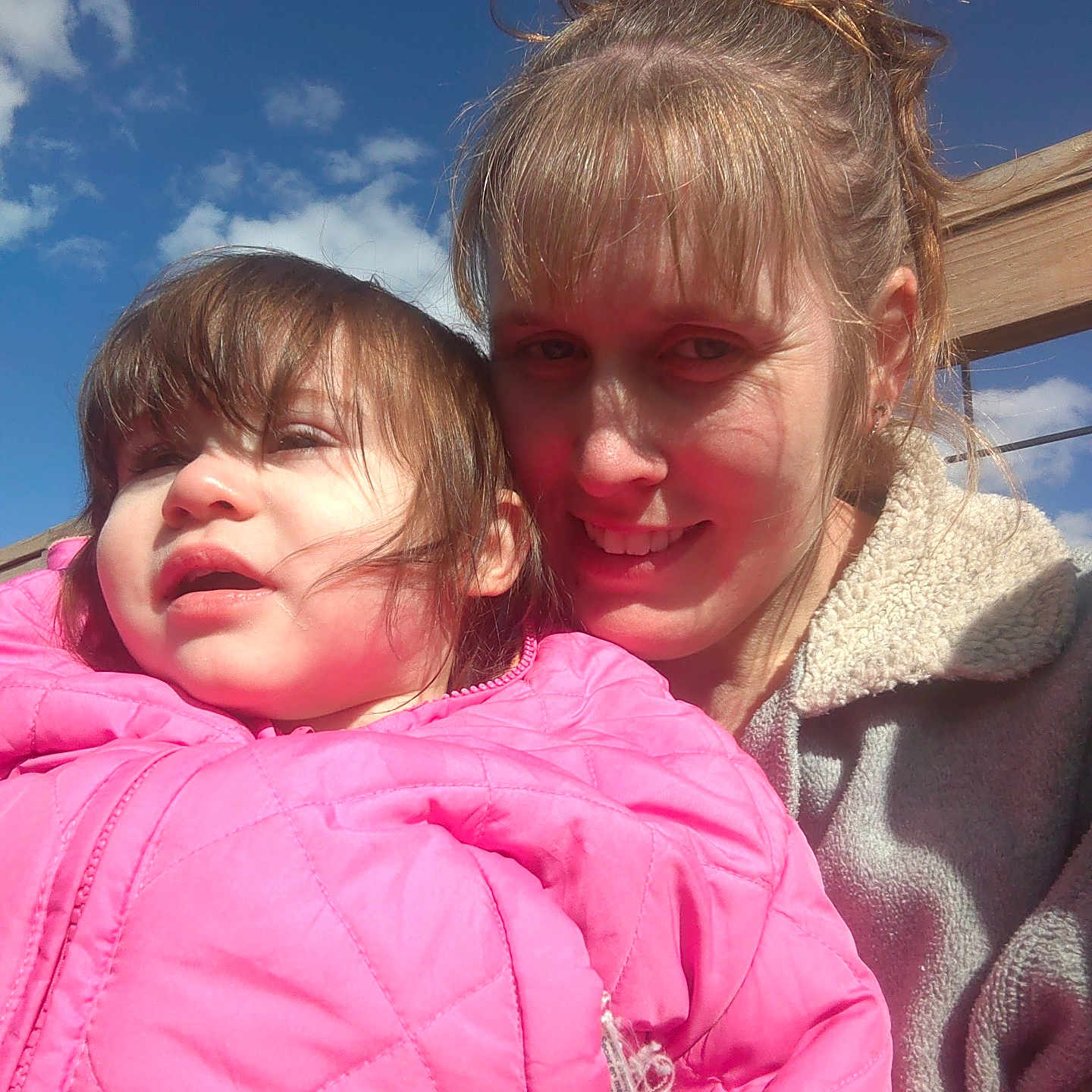 Julianna Rose joined the competition — help win amazing prizes! casual_clothing, child, clouds, daytime, face, hair, happy, jacket, nature, outdoor, people, pink, portrait, railing, sky, smile, sunlight, toddler, woman, wood